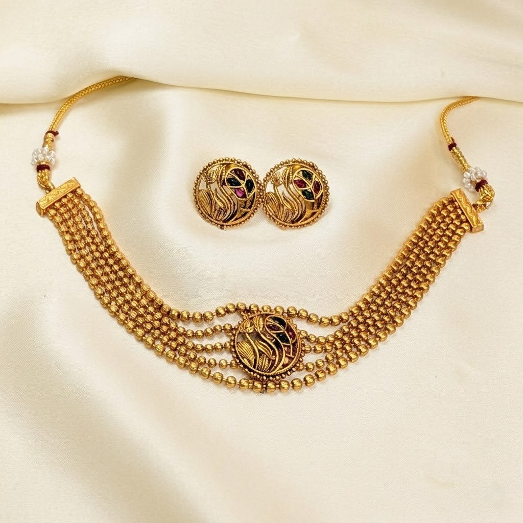 Gold necklace and earrings set on a beige background rashmi wedding necklace