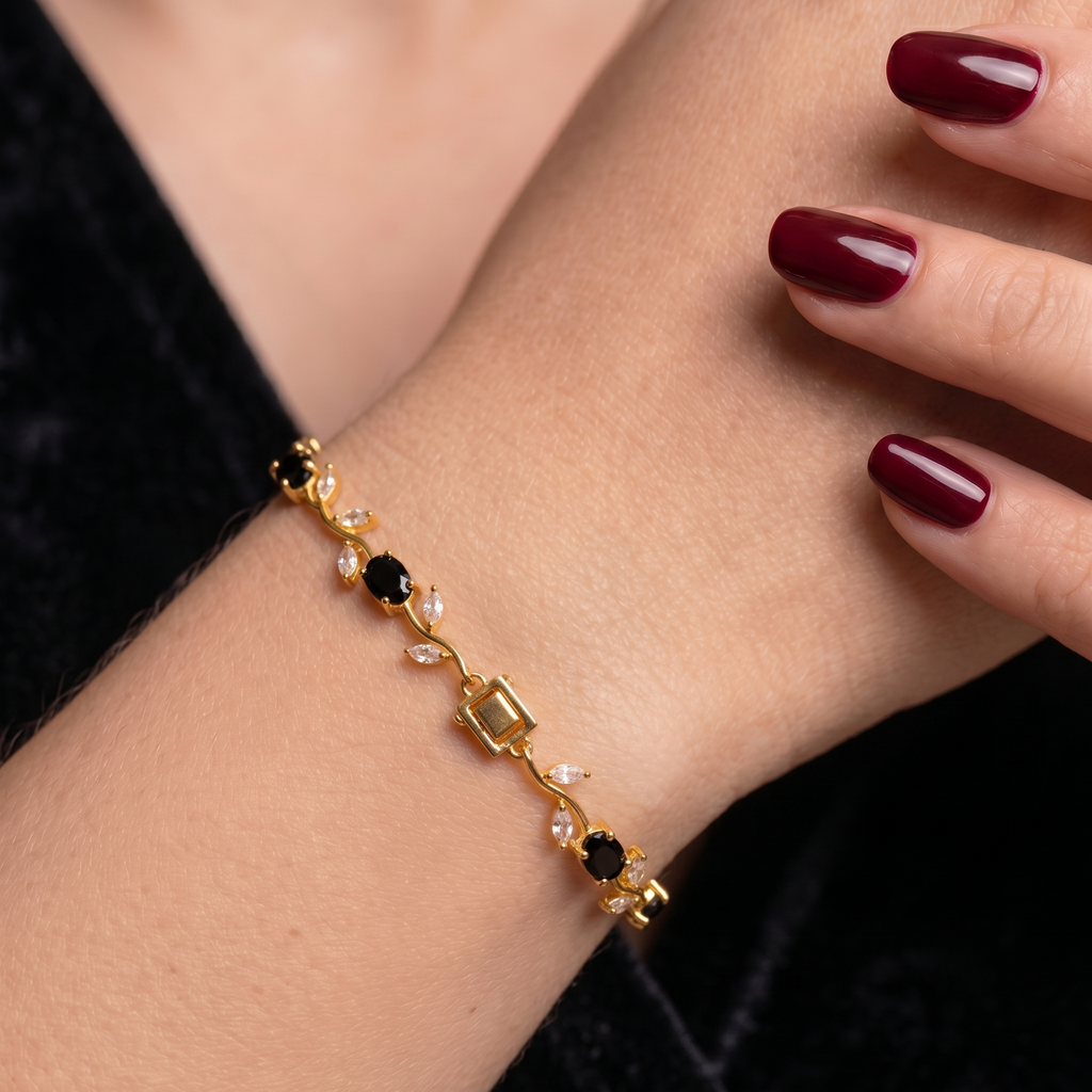 A gold bracelet with black and clear gemstones. ADFloral Vine tennis bracelet for girls.