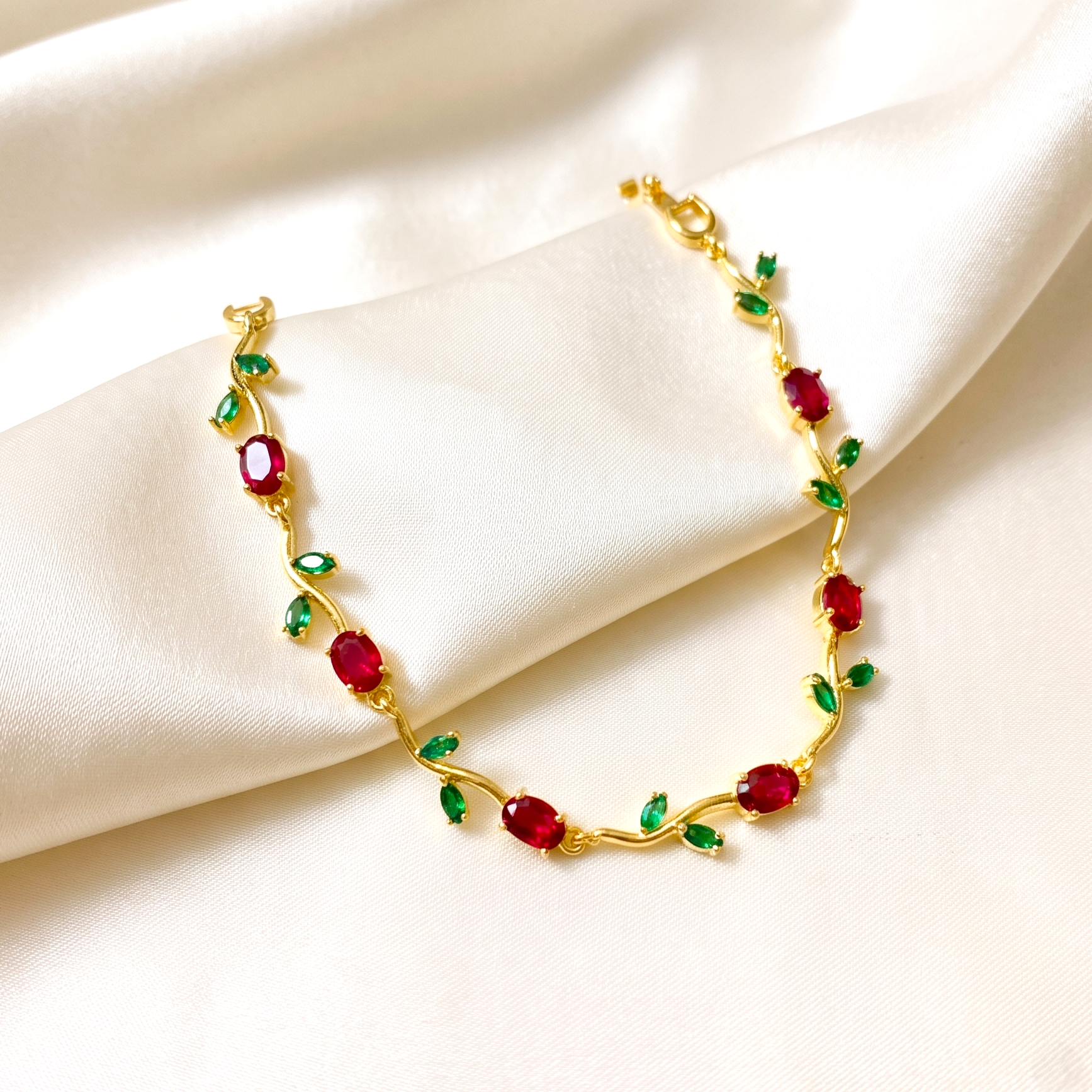  gold floral vine-style bracelet decorated with red oval gemstones and small green leaf accents partywear tennis girls bracelet