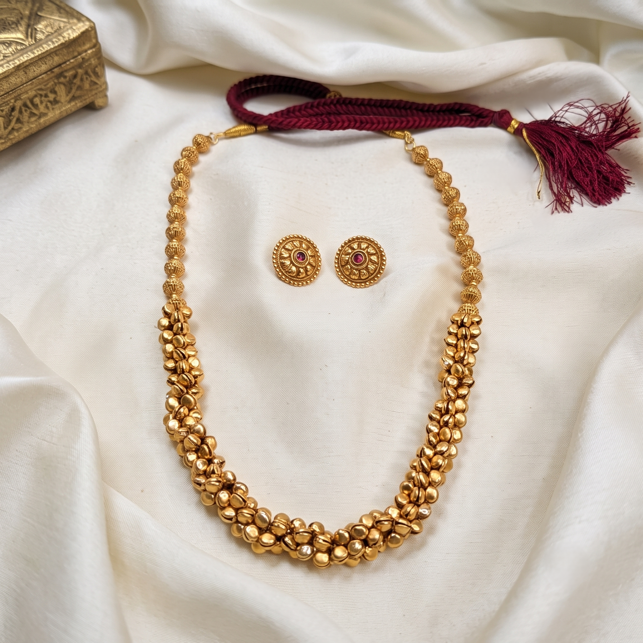 A gold-toned beaded ghungroo long necklace with a matching pair of stud earrings. Bharatnatyam necklace.