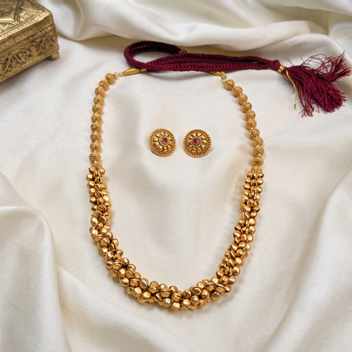 A gold-toned beaded ghungroo long necklace with a matching pair of stud earrings. Bharatnatyam necklace.