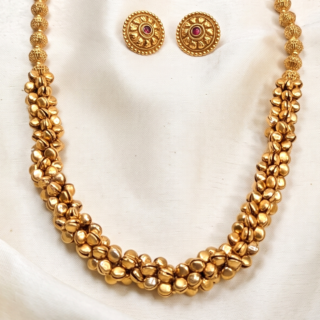 A gold-toned beaded ghungroo long necklace with a matching pair of stud earrings. Bharatnatyam necklace.