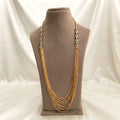 This is a multi-strand Chandraharam necklace featuring traditional Indian gold plating and sparkling stone side accents.
